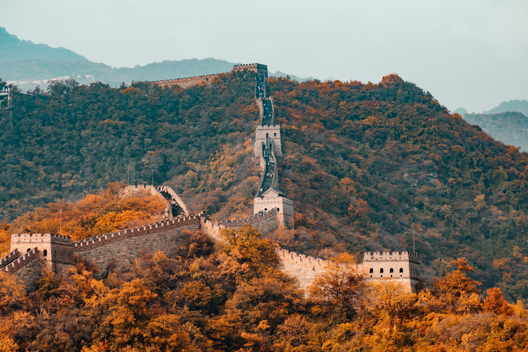 The Great Wall of China winding across forested mountains