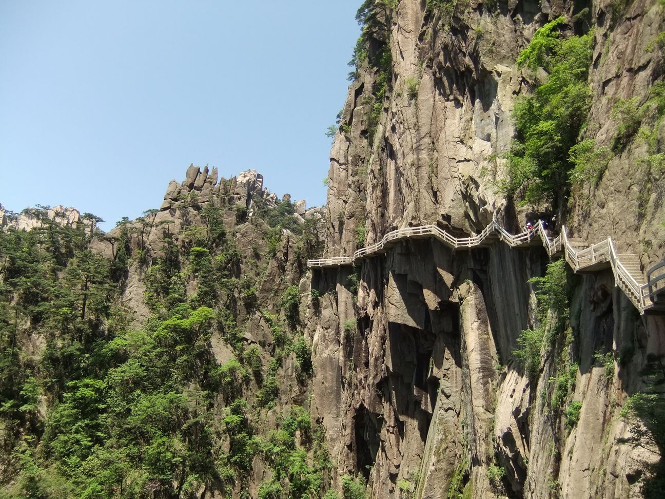 A built path with railings follows the cliff face in Huangshan's West Sea Canyon.