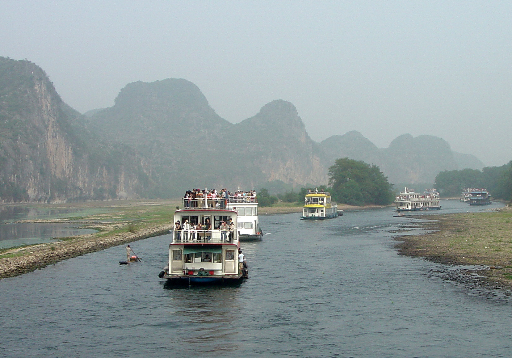 Cruise boats travelling between karst hills on the Li River from Guilin toward Yangshuo in 2006.