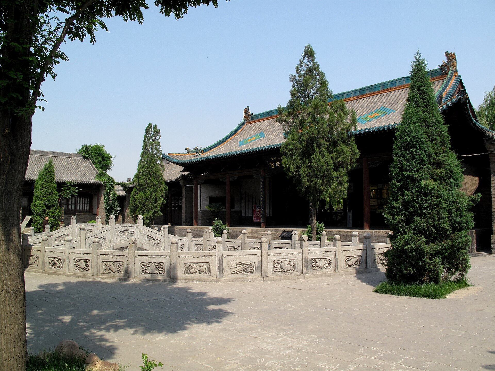 A stone bridge, pond, trees and hall stand in the courtyard of Pingyao Confucian Temple in 2009.