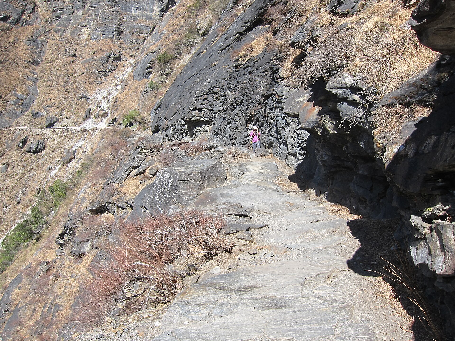 A narrow rocky trail crossing a steep gorge slope in a 2014 historical photograph from Tiger Leaping Gorge.
