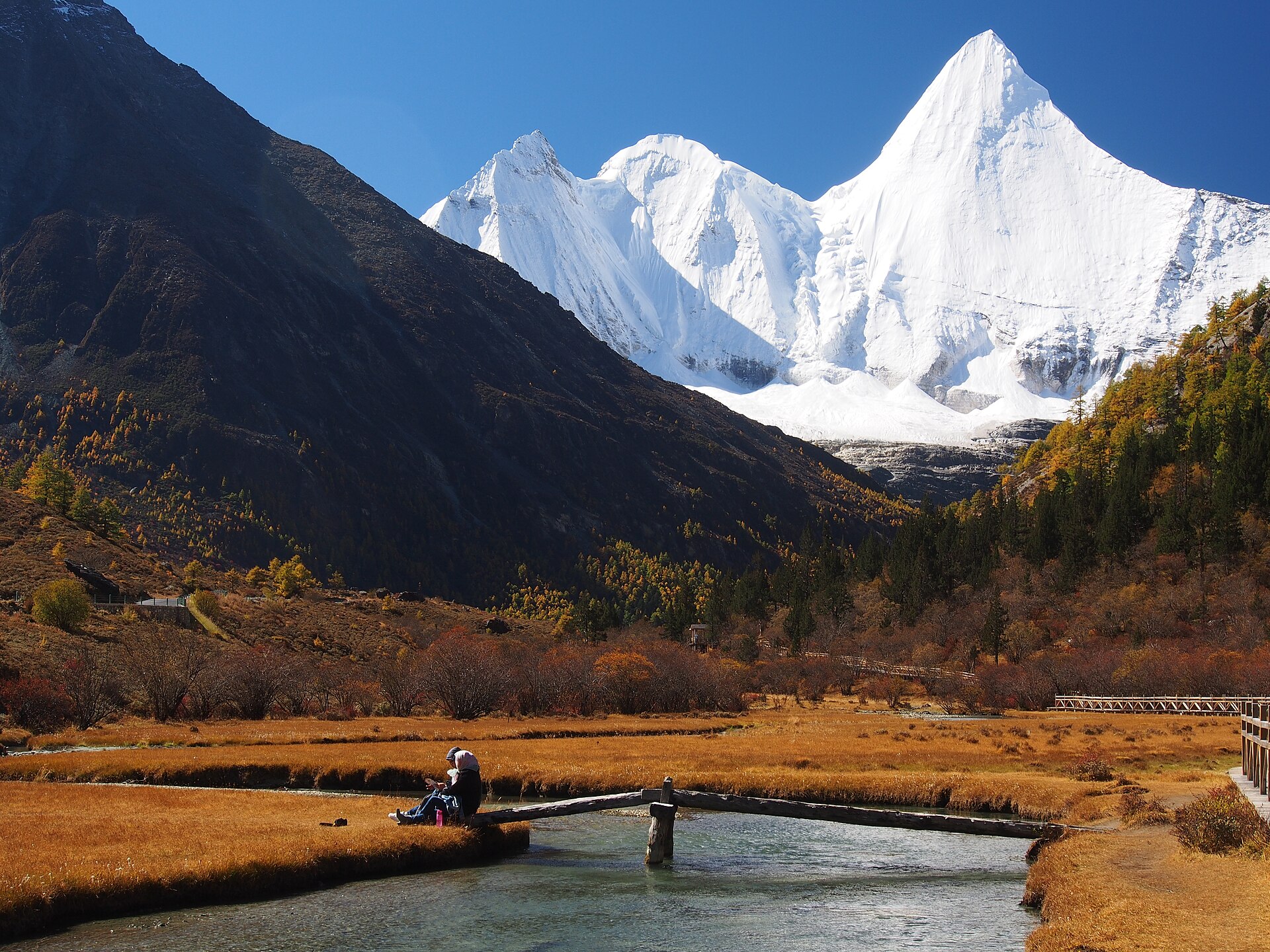 Yangmaiyong rises beyond an autumn meadow and stream in Yading National Nature Reserve in October 2016.