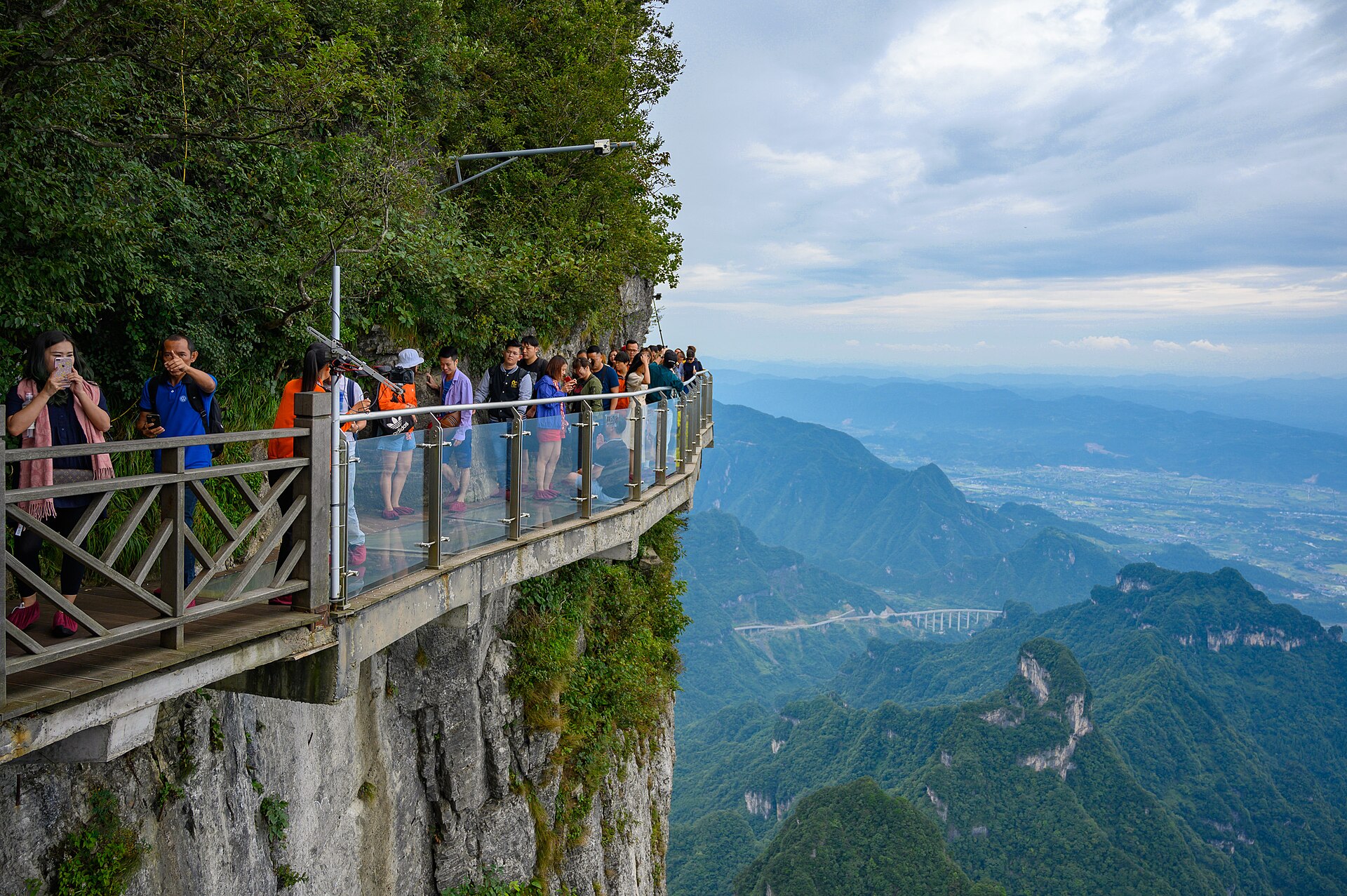 Visitors standing on the western glass walkway along a cliff at Tianmen Mountain in September 2019.