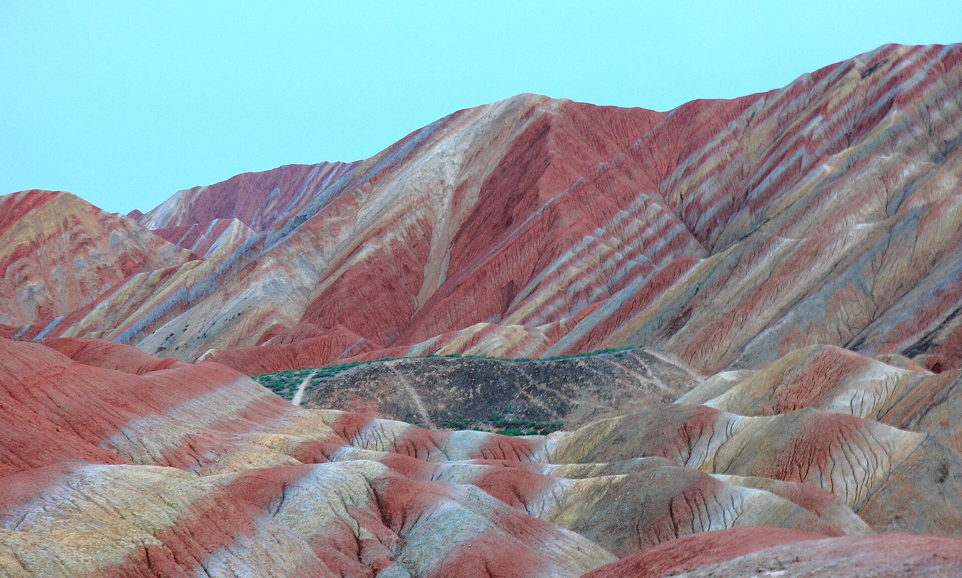 Layered red, ochre and pale hills rise in the Colorful Danxia area of Linze, Zhangye, in July 2013.